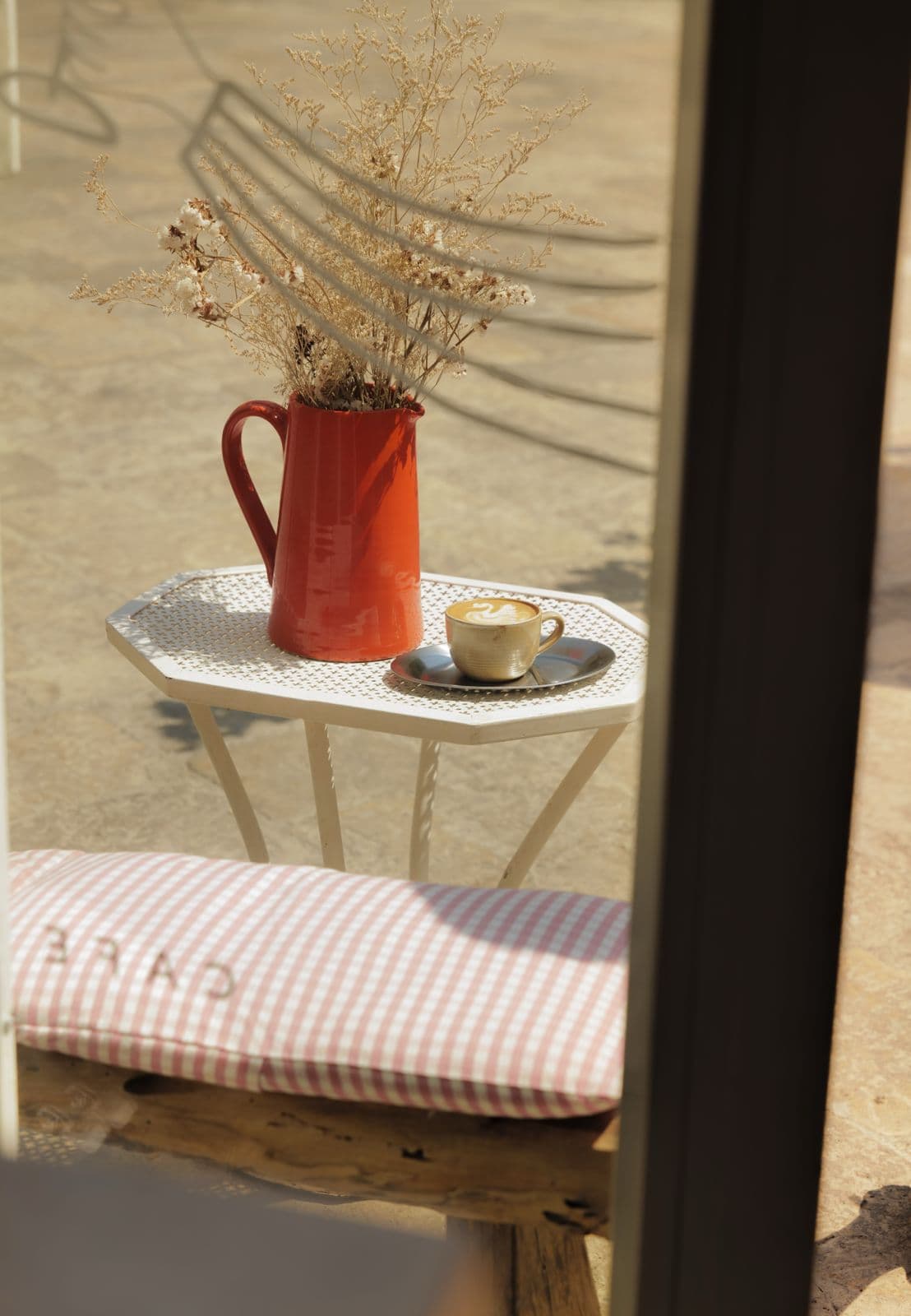 Tavolo esterno di Filiera Café con caffè e caraffa arancione